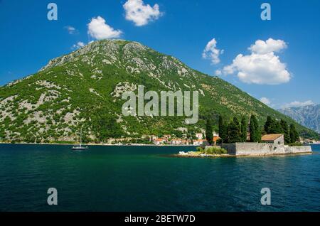 Monastero benedettiano di San Giorgio e chiesa sull'isola di San Giorgio Ostrvo Sveti Dende nella baia di Boka Kotor vicino alla città di Perast di fronte alle montagne della catena A. Foto Stock