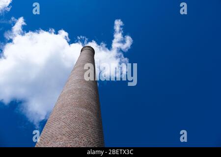 Vecchio mattone fumestack con cielo blu e nuvola sullo sfondo, fabbrica camino in mattoni con cielo blu e nuvola sullo sfondo Foto Stock