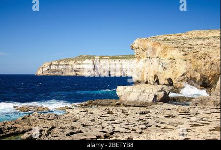 Costa rocciosa e mare vicino alla finestra crollata di Azure nella baia di Dwejra, isola di Gozo, Malta Foto Stock