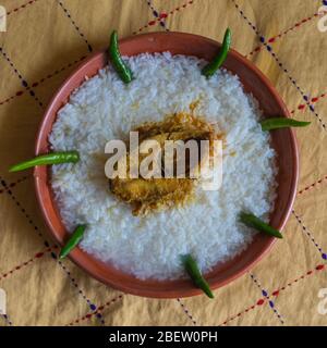 Cibi tradizionali bengalesi su piatto di terra chiamati Panta Ilish e Alu Vorta Foto Stock