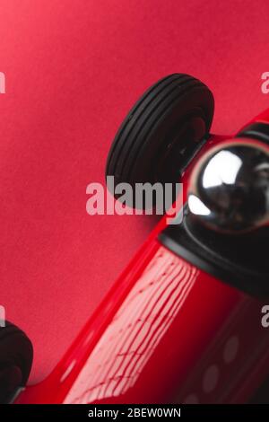 Giocattolo rosso vintage auto con numero cinque su un piatto primo piano ancora su uno sfondo rosso Foto Stock