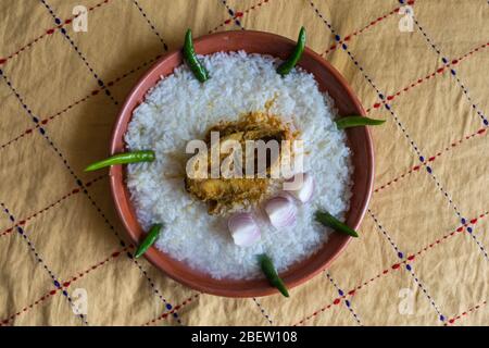 Cibi tradizionali bengalesi su piatto di terra chiamati Panta Ilish e Alu Vorta Foto Stock