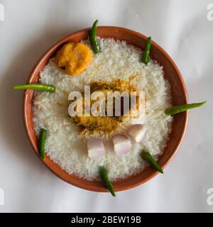 Cibi tradizionali bengalesi su piatto di terra chiamati Panta Ilish e Alu Vorta Foto Stock