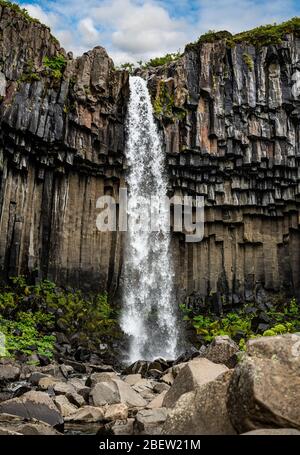 Cascata di Svartifoss circondata da colonne di basalto scuro in Islanda Foto Stock