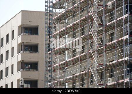 nuovo quartiere residenziale o quartiere in costruzione, case di appartamenti in diverse fasi di progresso con impalcatura o senza. Nuova soluzione vivente Foto Stock