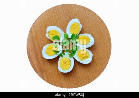 Le uova bollite con i rametti di rucola sono sul tagliere Foto Stock