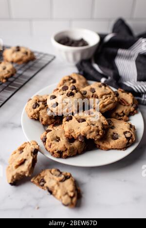 Primo piano dei biscotti appena sfornati con scaglie di cioccolato su un piatto. Foto Stock