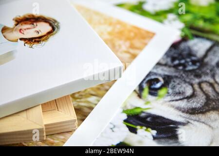 Stampe di quadri fotografici. Esempio di fotografia allungata di donna con avvolgi galleria. Foto stampate di un cane e di una coppia di nozze adagiate su un tavolo Foto Stock