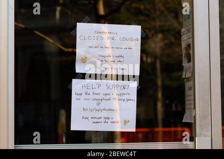 Segnali in una porta di una caffetteria nell'East Village di Manhattan che dicono che è temporaneamente chiuso a causa di coronavirus... PER ULTERIORI INFORMAZIONI, VEDERE LA DIDASCALIA COMPLETA Foto Stock