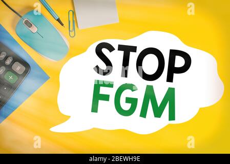 Nota di scrittura che mostra Stop FGM. Concetto di business per mettere una fine sul taglio genitale e circoncisione chiuso busta clip mouse calcolatrice matita nota c Foto Stock