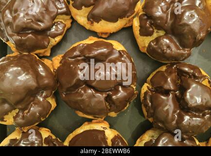 Vista dall'alto di un vassoio di pasticceria francese Choux con Ganache al cioccolato Foto Stock