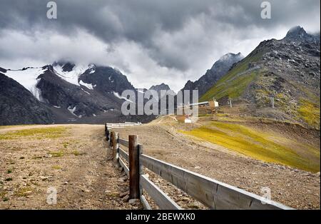 Splendido paesaggio delle montagne innevate a nuvoloso scuro dello sfondo del cielo in Shymbulak Ski Resort in Kazakistan Foto Stock