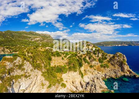 Paesaggio aereo di natura mediterranea in Grecia. Vista dall'aria sul monastero di Paleokastritsa, Corfù. Scogliera con alberi e bellissimo mare blu. Foto Stock