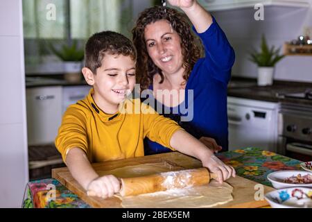 Madre e figlio che fanno l'impasto per fare una pizza Foto Stock