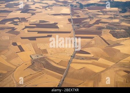 Vista aerea della regione di Madrid, al di fuori dell'area metropolitana. Sorvolando campi agricoli e strada. Spagna Foto Stock