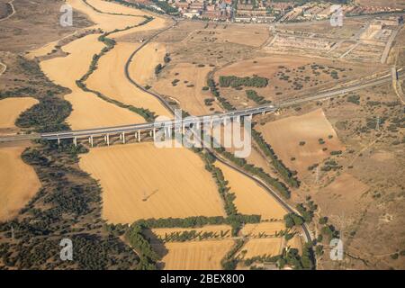 Vista aerea della regione di Madrid, al di fuori dell'area metropolitana. Sorvolando campi agricoli e strada. Spagna Foto Stock