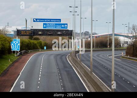 Autostrada vuota di m2 con lancette di lavaggio regolarmente cartello autostradale durante il blocco di coronavirus in Newtownabbey Irlanda del Nord Regno Unito Foto Stock