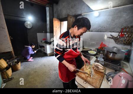 (200416) -- RONGAN, 16 aprile 2020 (Xinhua) -- Gexiong lungo cuoce un piatto per i turisti nella cucina della sua casa a Tongbantun Villaggio di Dongqi Township nella Contea di Rongan, regione autonoma di Guangxi Zhuang della Cina del sud, 12 aprile 2020. Long Gexiong, 52 anni, lasciò la sua città natale a 24 anni e andò a caccia di lavoro nella città di Liuzhou, nella regione autonoma di Guangxi Zhuang, nel sud della Cina. Dopo due decenni di lavoro all'esterno, tornò finalmente al suo villaggio nelle profonde montagne. A lungo è caduto fuori dalla scuola nel 1986 a causa della povertà e ha scosso una vita piantando alberi di susina. Tuttavia, colline e wa sterili Foto Stock