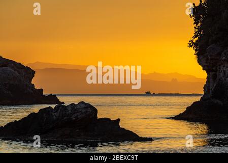 Vista mozzafiato dell'alba dalla spiaggia migliore di Taormina - Mazzaro, vicino alla Riserva Naturale Isolabella, Sicilia Foto Stock