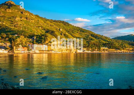 Luce dorata del mattino che si riflette nel mare turchese nella splendida baia di Mazzaro, Taormina, Provincia di Messina, Sicilia Foto Stock