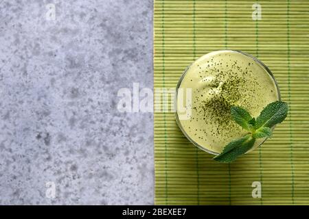 Dalgona Iced Matcha tè, latte freddo e cubetto di ghiaccio guarnire menta. Vista dall'alto. Spazio per la ricetta. Foto Stock