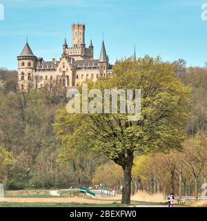 Nordstemmen, Germania, 15 aprile 2020: Palazzo Marienburg dietro un albero in primavera con foglie verdi libere Foto Stock