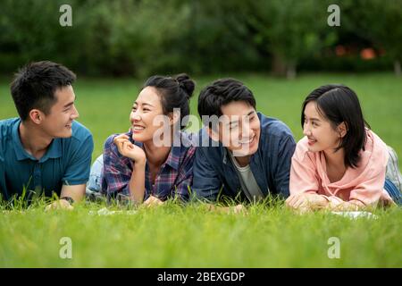 Felicità degli studenti universitari si trovano sull'erba chiacchierando Foto Stock