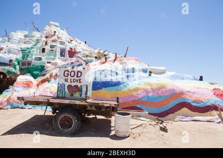 Salvation Mountain colline colorate e un rimorchio con slogan dipinto Dio è Amore Foto Stock