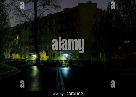 Cracovia, Polonia - 16 aprile 2020: Le autorità hanno spento l'illuminazione stradale per risparmiare denaro durante la pandemia COVID-19. Miechowity strada nel buio. Foto Stock