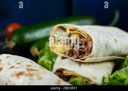 Lo shaurma di carne si arrotola in un piatto con verdure miste Foto Stock