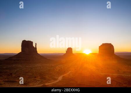 USA Stati Uniti d'America Monument Valley il sole sorge all'orizzonte all'alba dello Utah, Arizona Navajo Nation Tribal Park Foto Stock