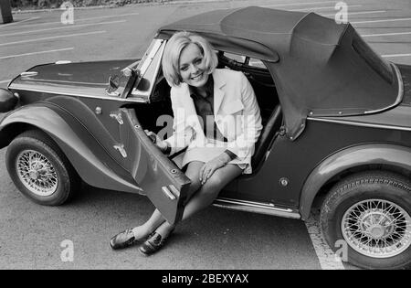 Victoria Voncampe, deutsche Fernsehansagerin, Moderatorin und Schauspielerin, mit ihrem kleinen Fiat Cabrio, Deutschland um 1969. Presentatore, ospite e attrice della TV tedesca Victoria Voncampe con la sua piccola Fiat convertibile, Germania intorno al 1969. Foto Stock