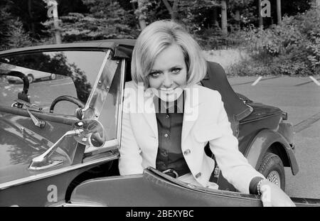 Victoria Voncampe, deutsche Fernsehansagerin, Moderatorin und Schauspielerin, mit ihrem kleinen Fiat Cabrio, Deutschland um 1969. Presentatore, ospite e attrice della TV tedesca Victoria Voncampe con la sua piccola Fiat convertibile, Germania intorno al 1969. Foto Stock