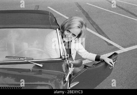 Victoria Voncampe, deutsche Fernsehansagerin, Moderatorin und Schauspielerin, mit ihrem kleinen Fiat Cabrio, Deutschland um 1969. Presentatore, ospite e attrice della TV tedesca Victoria Voncampe con la sua piccola Fiat convertibile, Germania intorno al 1969. Foto Stock