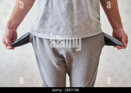 Tasche vuote capovolte. Il giovane uomo ha esaurito le tasche dei jeans. Foto Stock