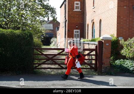 Loughborough, Leicestershire, Regno Unito. 16 aprile 2020. Il postino reale della posta Kevin Allen indossa il vestito incredibile di fantasia del signor a sostegno del NHS mentre trasporta il posto durante il lockdown pandemic del coronavirus. Credit Darren Staples/Alamy Live News. Foto Stock