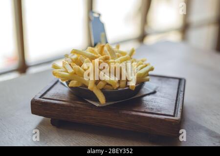 Patatine fritte in padella su tavolo di legno Foto Stock