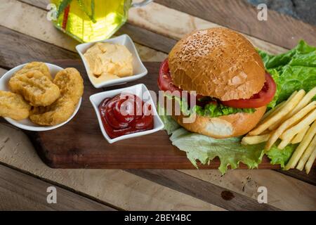 Hamburger, involtini di cipolle e patate fritte con salse Foto Stock