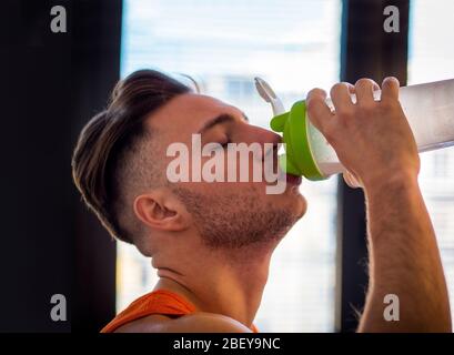 Giovane uomo bere un frullato o bere un frullato di proteine Foto Stock