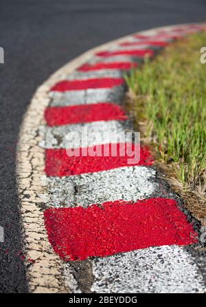 Cordoli da corsa dipinti in rosso e bianco sul circuito di carting Foto Stock