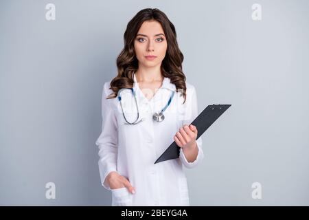 Foto di bello professionista doc medico intern signora tenere le carte del paziente prescrizioni mediche indossare bianco stetoscopio cappotto isolato grigio Foto Stock