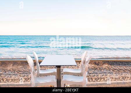 Spiaggia vuota caffè senza visitatori, persone. Sedia da spiaggia vuota, tavolo, baia, mare, non turistico. Divieto di viaggio in Europa. Stagione turistica COVID-19. Chiuso re Foto Stock