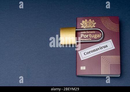 Passaporto europeo portoghese con lucchetto su sfondo blu. Foto Stock