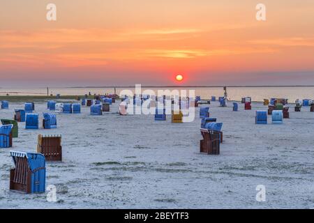 Sedie da spiaggia in vimini sulla spiaggia di Dornumersiel al tramonto, Frisia orientale, bassa Sassonia, Germania Foto Stock