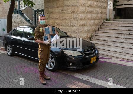 Gerusalemme, Israele. 16 Apr 2020. Un soldato IDF del comando principale entra in un edificio residenziale che offre pacchetti alimentari per uno dei 350,000 anziani idonei a livello nazionale, sotto quarantena a casa di Coronavirus. Il Ministero della Difesa condivide le responsabilità per la gestione della crisi COVID-19. Credit: NIR Alon/Alamy Live News Foto Stock