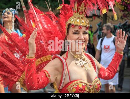 Partecipante e ballerini in colorato costume caraibico al festival e sfilata di strada di Notting Hill, Londra, Regno Unito Foto Stock