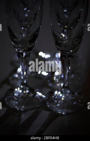 Bicchieri di champagne in cristallo illuminato in una stanza buia. Concetto : minimalismo artistico. Foto Stock