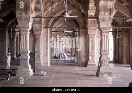 INTERIOR-ARCADAS DE LA MEZQUITA CON GENTE REZANDO AL FONDO. Autore: QUDSIA BEGUM. LOCALITÀ: MEZQUITA JAMI MASJID. Bhopal. India. Foto Stock