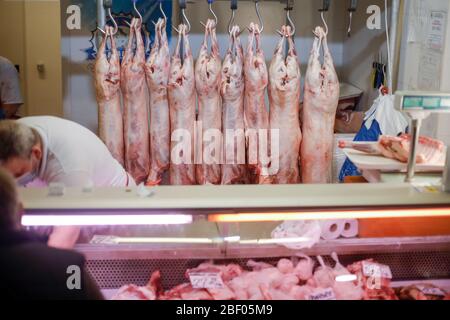 Bucarest, Romania - 16 aprile 2020: Carcassa di agnello appesa da ganci di ferro per la vendita in un macellaio rumeno prima di Pasqua. Foto Stock