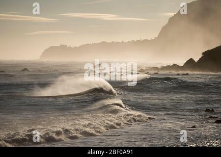 Onde e vento sulla costa tra la città di Porto Moniz e Ribeira da janela sull'isola di Madeira nell'Oceano Atlantico del Portogallo. Madeira, po Foto Stock